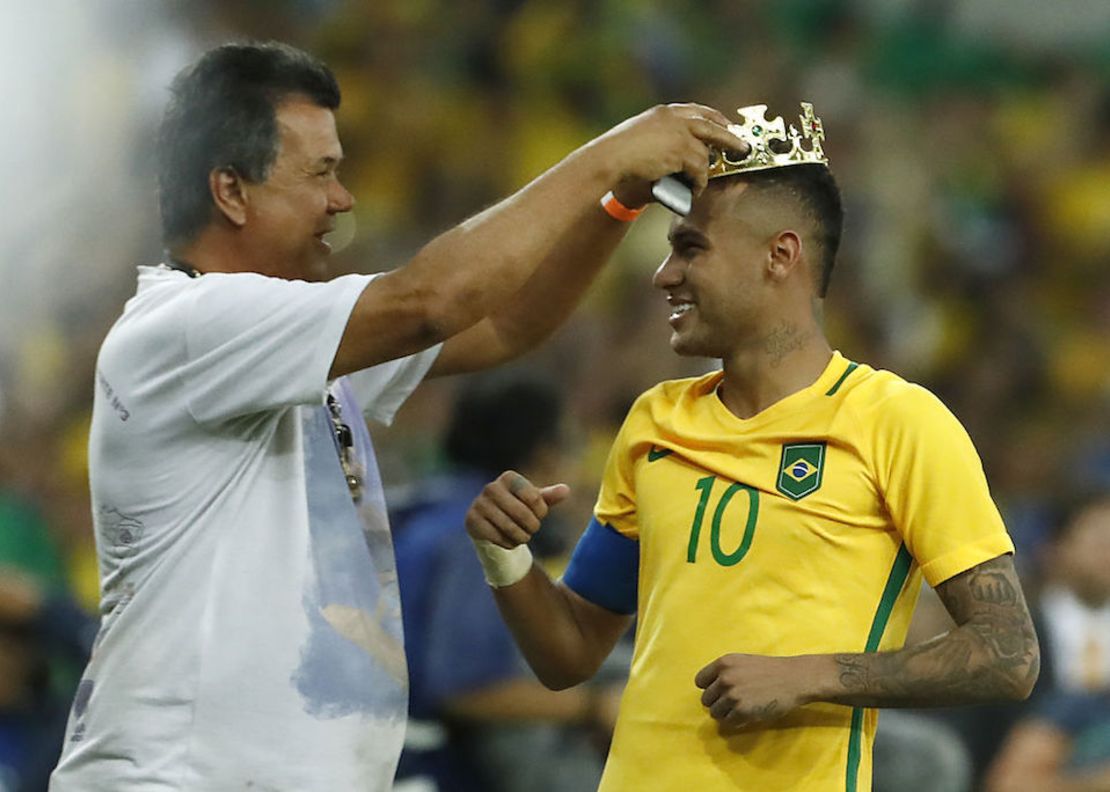 El delantero brasileño Neymar recibe una corona tras la victoria de su selección en la final del fútbol de los Olímpicos de Río.