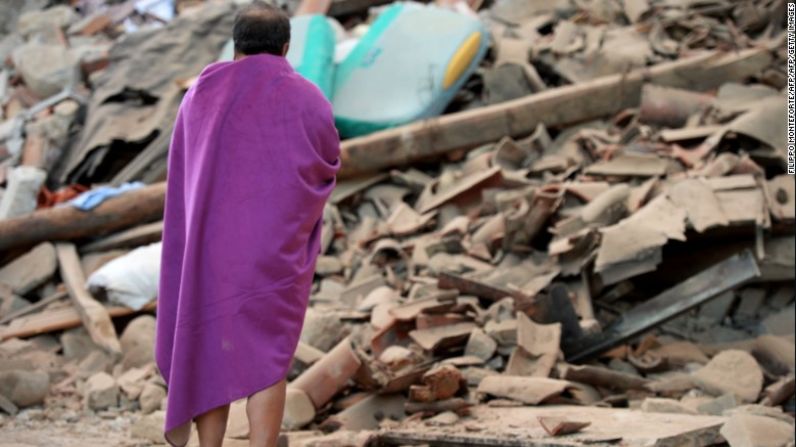 Un hombre mira los escombros de una casa en Amatrice.