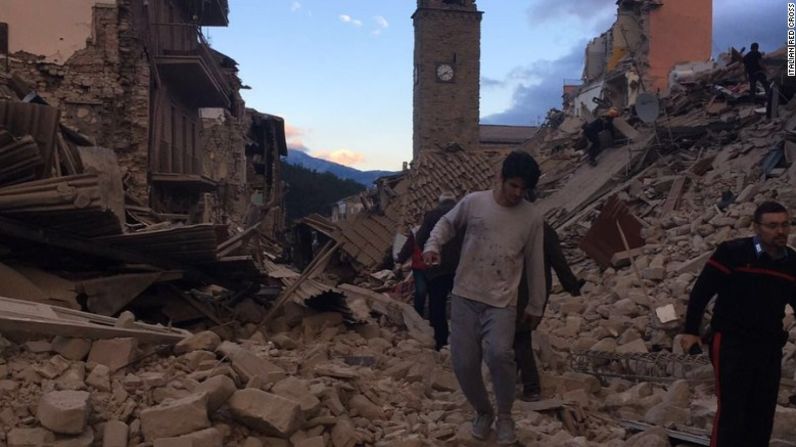 Residentes caminan entre los escombros en Amatrice.