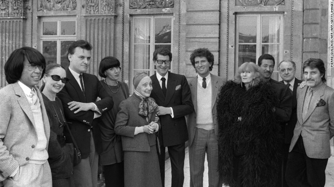 Sonia Rykiel (con abrigo de plumas negras) posa con el Ministro de Cultura francés Jack Lang (séptimo de izquierda a derecha) y sus contemporáneos de la moda en París en 1984.