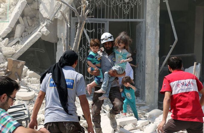 Equipos de emergencia se apresuran para poner a salvo a varios niños en Aleppo, después de un bombardeo con bombas de barril.