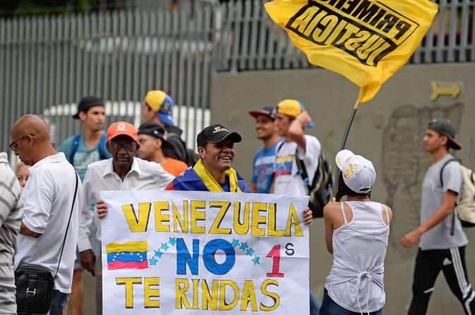 "Venezuela no te rindas", dice una pancarta que llevan los manifestantes.