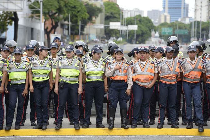 Miembros de la policía venezolana permanecen de pie frente a la marcha opositora en Caracas este 1 de septiembre de 2016.