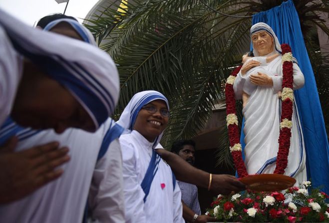 Monjas de la India se reúnen para rezar en torno a una estatua de la Madre Teresa en una iglesia de Chennai.