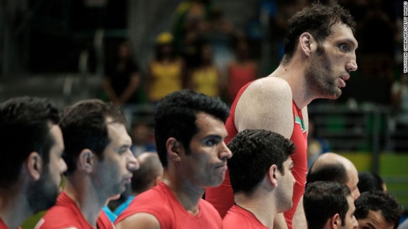 El hombre más alto de Irán, Morteza Mehrzadselakjani, antes del partido de voleibol sentado ante Ucrania.