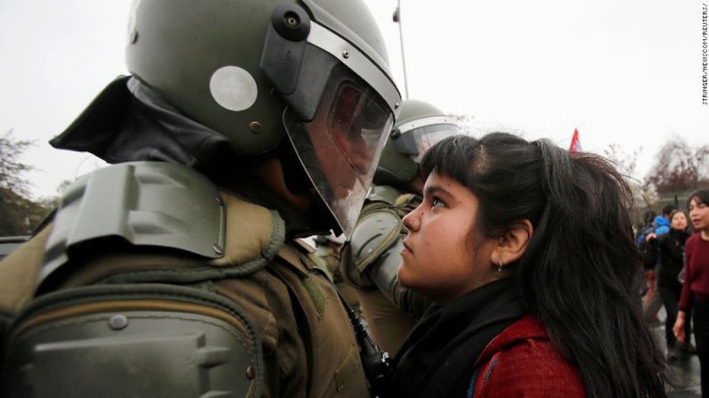 Una mirada desafiante en Chile — Esta imagen en la que una joven mira de manera desafiante a un policía antidisturbios se volvió viral en internet esta semana. La mujer aún no identificada fue fotografiada durante las protestas en Santiago por el aniversario 43 del golpe militar en el que el presidente Salvador Allende fue derrocado y asesinado y reemplazado por el gobierno militar liderado por Augusto Pinochet. La foto fue compartida miles de veces en redes sociales.