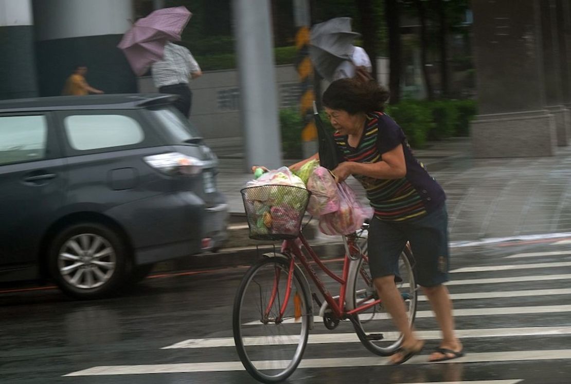 Una mujer empuja su bicicleta en Taipei