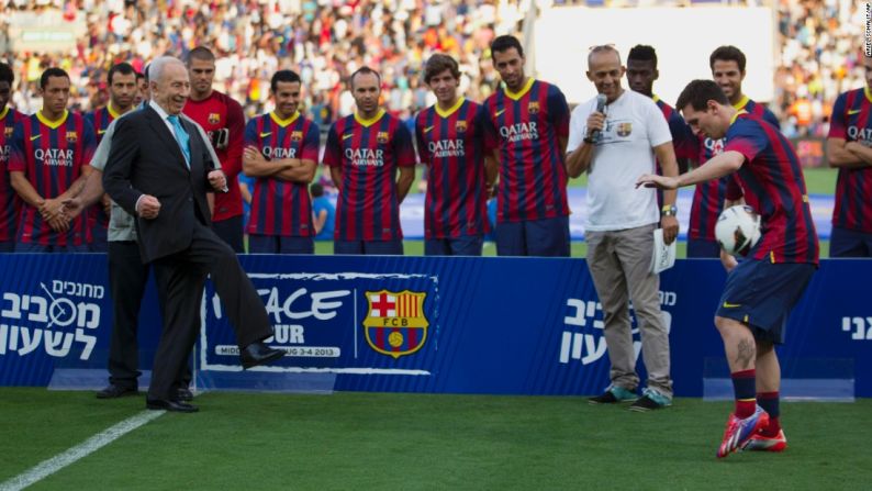 Peres le pasa el balón a Messi durante un partido de demostración en Tel Aviv en 2013.