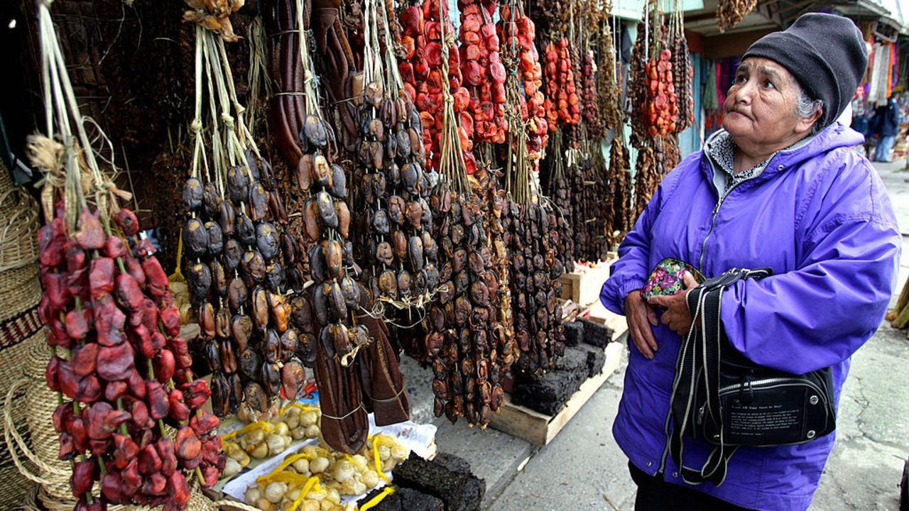 An old woman looks for smoked seafood at "Angelmo"  typical market in Puerto Montt,1000 km south of Santiago, 26th October 2007. Products like mussels and clams are typical seafoofd from Chile's southern coast. AFP PHOTO MARTIN BERNETTI