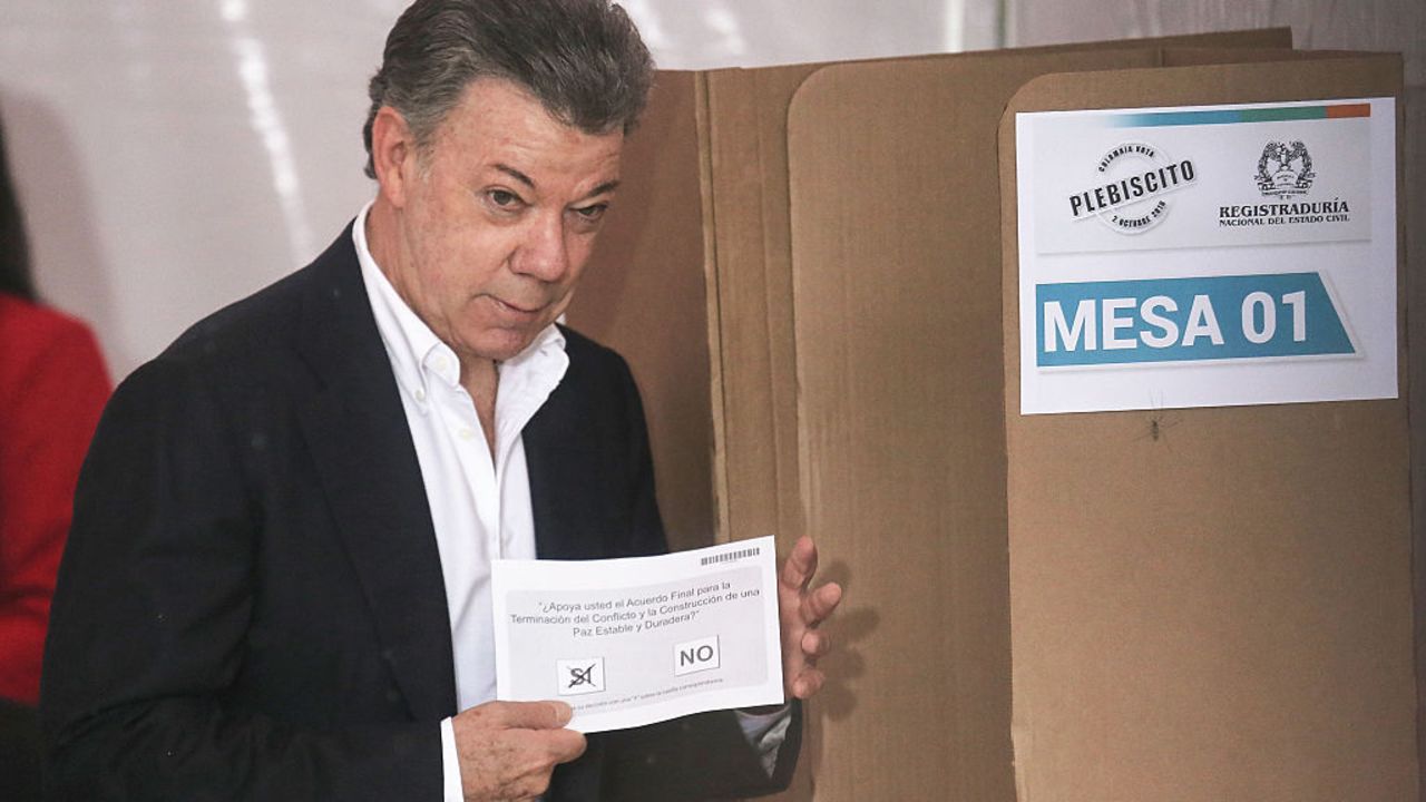 BOGOTA, COLOMBIA - OCTOBER 02:  Colombia's President Juan Manuel Santos holds his ballot in the referendum on a peace accord to end the 52-year-old guerrilla war between the FARC and the state on October 2, 2016 in Bogota, Colombia. The guerrilla war is the longest-running armed conflict in the Americas and has left 220,000 dead. The plan calls for a disarmament and re-integration of most of the estimated 7,000 FARC fighters.