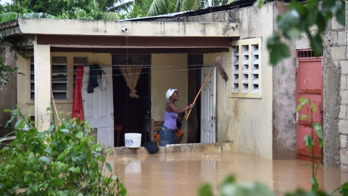 Una mujer limpia su casa inundada después de que el río La Rouyonne se desbordara inundando la comuna de Leogane.