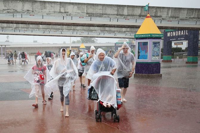 Visitantes abandonan el parque de Disney en Orlando en medio de una fuerte lluvia. El parque fue cerrando ante la llegada del huracán.