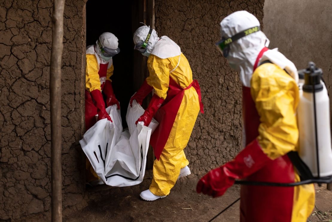 Trabajadores de la Cruz Roja cargan una bolsa para cadáveres desde el interior de una casa, de un caso sospechoso de ébola el 13 de octubre de 2022 en Mubende, Uganda.