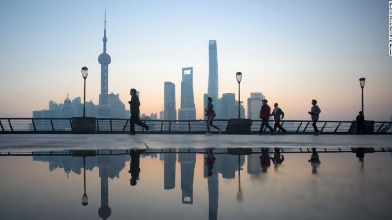 Shanghai, China. 2015. Los shanghaianos hacen sus ejercicios matutinos con esta espectacular vista del distrito financiero en Pudong, Shanghai.