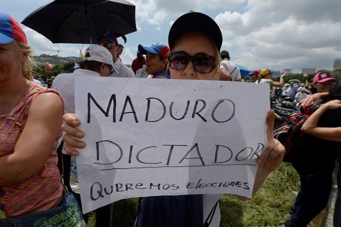 Una mujer sostiene un cartel en el que se lee “Maduro dictador: queremos elecciones”, durante la gran marcha convocada por la oposición al Gobierno de Nicolás Maduro, en Venezuela.