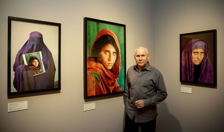 Arrestan a la 'niña afgana' de NatGeo — Sharbat Gula, la mujer afgana con deslumbrantes ojos verdes que fue portada de la revista National Geographic cuando era niña, fue arrestada en Pakistán este martes por falsificar documentos y permanecer de forma ilegal en Pakistán, dijeron las autoridades. En esta imagen aparece Steve McCurry, quien tomó la icónica fotografía.