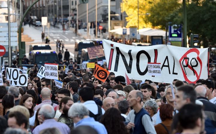 Los manifestantes concentrados ante la calle, cerrada, del Congreso de Diputados, donde se votaba la investidura de Rajoy.