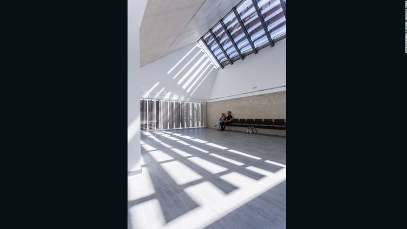 El edificio de concreto tiene ventanas que proyectan sombras a lo largo del cuarto. Dichas sombras cambian de acuerdo a la hora, un símbolo del paso del tiempo.