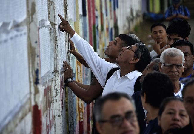 Varios votantes revisan las listas de electores, en una mesa de votación en Managua. Nicaragua elige a su presidente.