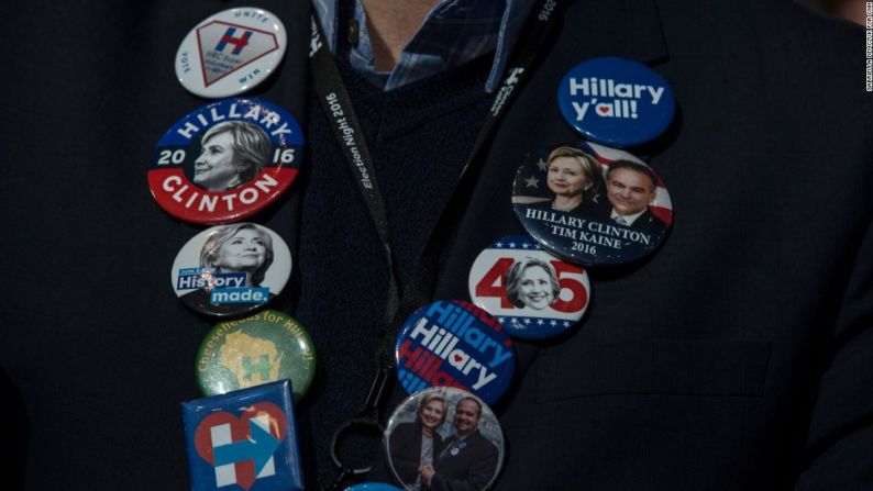 Una partidaria de Hillary Clinton lleva puestos prendedores de la candidata republicana en el Javits Center de Nueva York.