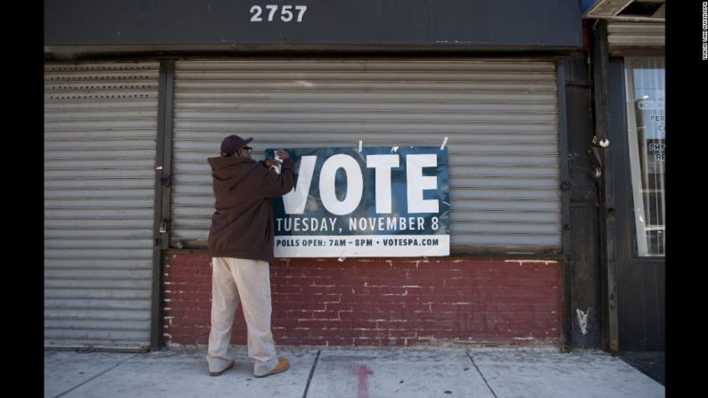 Un hombre en Filadelfia cuelga un cartel para recordarle a la gente la importancia de votar.