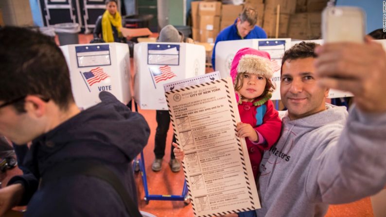 Un hombre se toma una ‘selfie’ con su hijo, mientras espera para votar en Brooklyn, Nueva York.