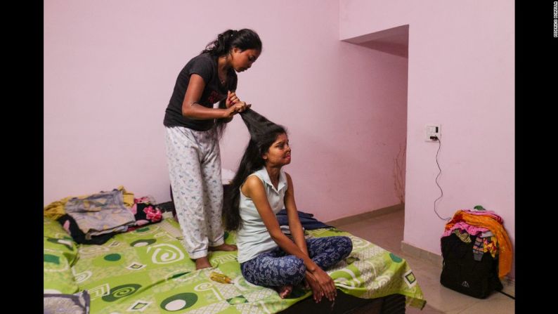 Dolly trenza el pelo de Ritu. Las dos mujeres trabajan en el café que fue fundado por la organización sin ánimo de lucro basada en Nueva Delhi, ‘Stop Acid Attacks’.