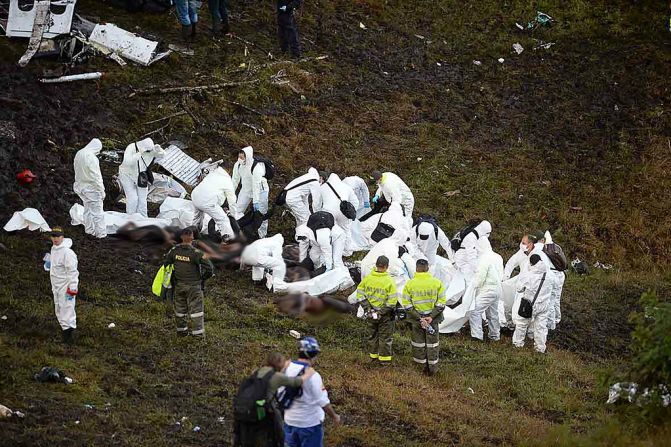 Miembros del equipo forense recuperan los cuerpos de las víctimas del accidente.