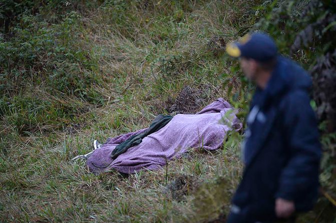 Un rescatista camina junto al cuerpo de una víctima.