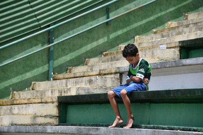 Un niño se sienta solo en las graderías del estadio del Chapecoense durante un tributo a los jugadores y miembros del equipo fallecidos en el accidente aéreo en Colombia.