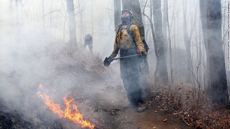 El bombero Layne Whitney revisa las cumbres de los árboles, mientras intentan contener el fuego que consume el norte de Rock Mountain, al norte de Tate City, en Georgia, el pasado martes 22 de noviembre.