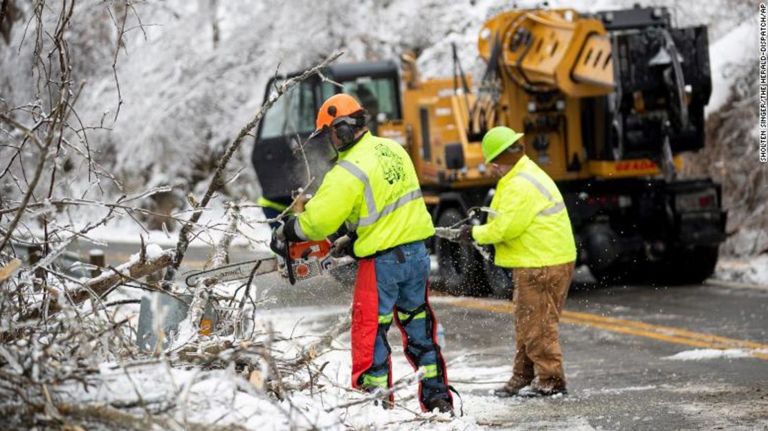 Trabajadores retiran ramas caídas y nieve en Huntington, Virginia Occidental.