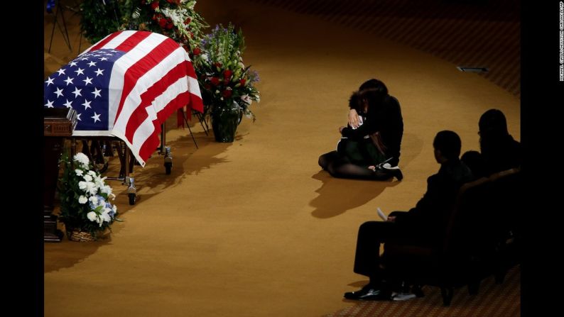 Junio 21: Lucy Lugo, esposa del fallecido oficial de policía Endy Kepanya, consuela a su hijo, Julian, durante su funeral en Houston. Ekpanya, un oficial de policía en Pearland, Texas, murió tras ser atropellado.