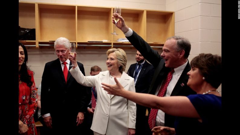 Julio 27: Hillary Clinton, candidata presidencial del Partido Demócrata, sostiene una copa mientras celebra entre bastidores en la Convención Nacional Demócrata. Entre los que se unieron a ella estaban su esposo, el expresidente estadounidense Bill Clinton, y su compañero de equipo, el senador Tim Kaine.