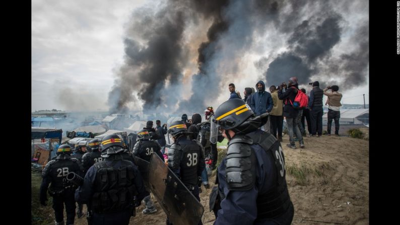 Octubre 26: el humo que surge de "La jungla", un campamento improvisado de migrantes en Calais, Francia, que las autoridades empezaron a desmantelar el 24 de octubre. Durante las evacuaciones, algunos inmigrantes incendiaron los refugios. A mitad de semana, más de 4.400 personas habían sido trasladadas de Calais a otras regiones del país. Esta ciudad es conocida por ser un importante punto de tránsito de los inmigrantes que intentan llegar a Gran Bretaña.