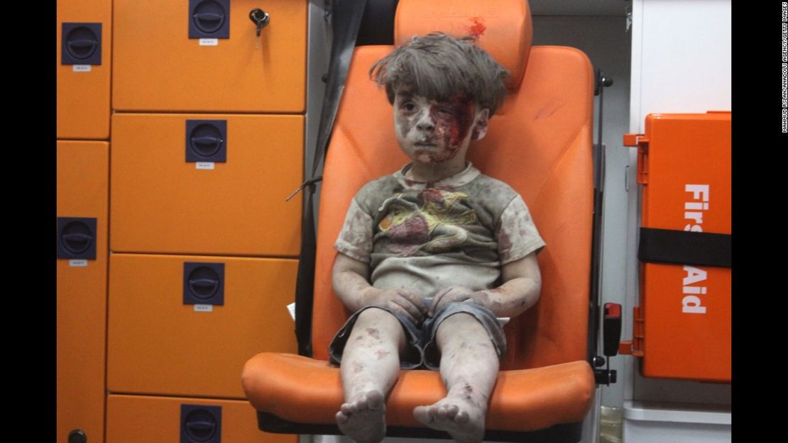 Agosto de 2016: Esta imagen, un fotograma de un video publicado por el Centro de Medios de Aleppo, muestra a un niño en una ambulancia tras un ataque aéreo en Aleppo, Siria. Les tomó a los socorristas casi una hora sacar el menor, identificado como Omran Daqneesh, de los escombros, le dijo un activista a CNN. El ataque destruyó su hogar, en donde vivía con sus padres y dos hermanos.