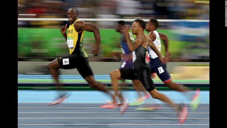 El velocista jamaiquino Usain Bolt mira hacia atrás a sus competidores en la semifinal de los 100 metros planos. Bolt ganó la final después, convirtiéndose en el primer hombre en la historia en ganar los 100 metros en tres olimpiadas consecutivas.