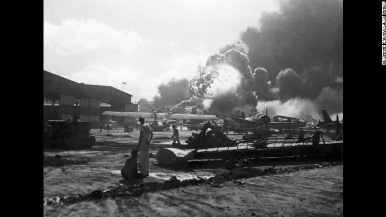 Pilotos de la Base de la Fuerza Aérea Hickam Field de Estados Unidos observan cómo explotan las bombas. Este lugar fue fuertemente atacado durante la ofensiva japonesa, cuyos bombardeos buscaban prevenir una respuesta de parte de las fuerzas de Estados Unidos. Por eso, dejaron inhabilitados todos los aviones estadounidenses que estaban en tierra.