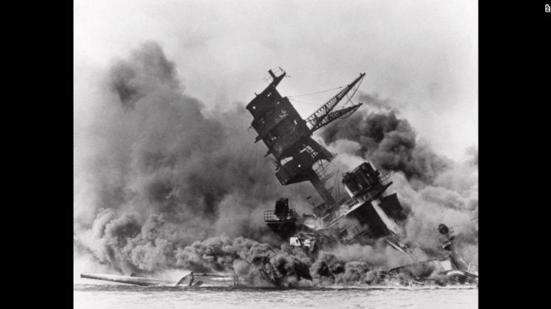 Las columnas de humo envuelven el barco de batalla USS Arizona mientras se desploma antes de hundirse en Pearl Harbor.