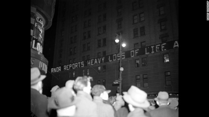 Multitudes de personas se reúnen en el Times Square de Nueva York mientras los boletines de noticias anuncian Harbor en el edificio del New York Times el ataque a Pearl Harbor.