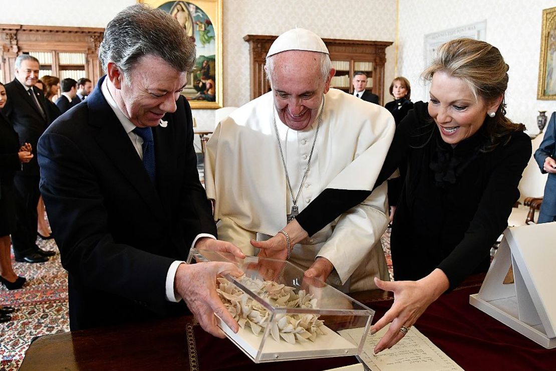 La primera dama de Colombia (d), María Clemencia Rodríguez, le presenta al papa un regalo.