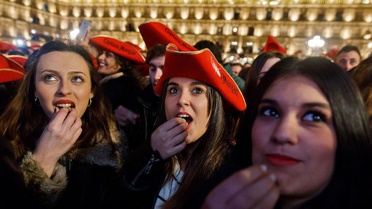 Students eat grape gummies while celebrating the traditional year-end party held in the main square of Salamanca, Spain on December 15, 2016. 
The student end of year party has been celebrated every year since the 1990s in the main square of Salamanca in northern Spain, and this year's version drew 35,000 university students on December 15, 2016. / AFP / CESAR MANSO