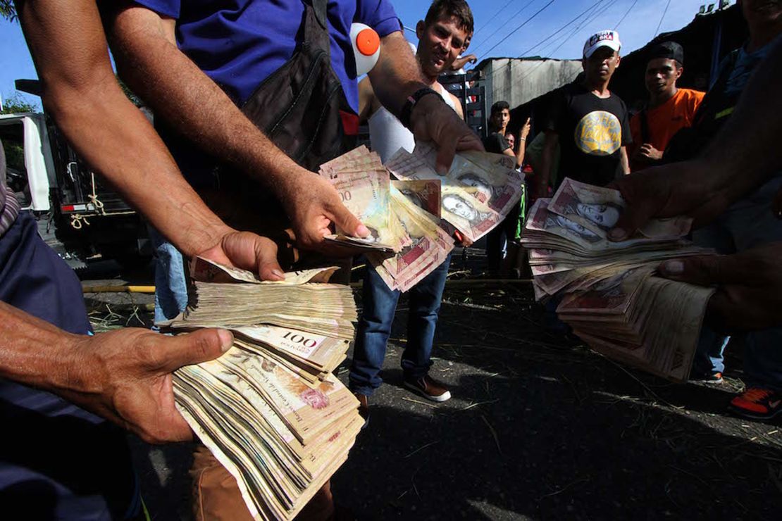 Venezolanos hacen filas para el cambio de billetes de 100 bolívares, que han sido descontinuados.