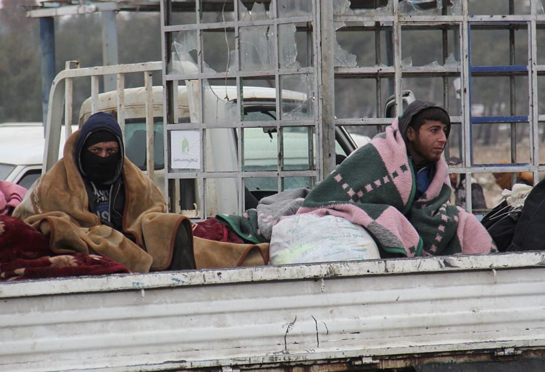 Dos hombres sirios son evacuados de Aleppo  a bordo de un camión