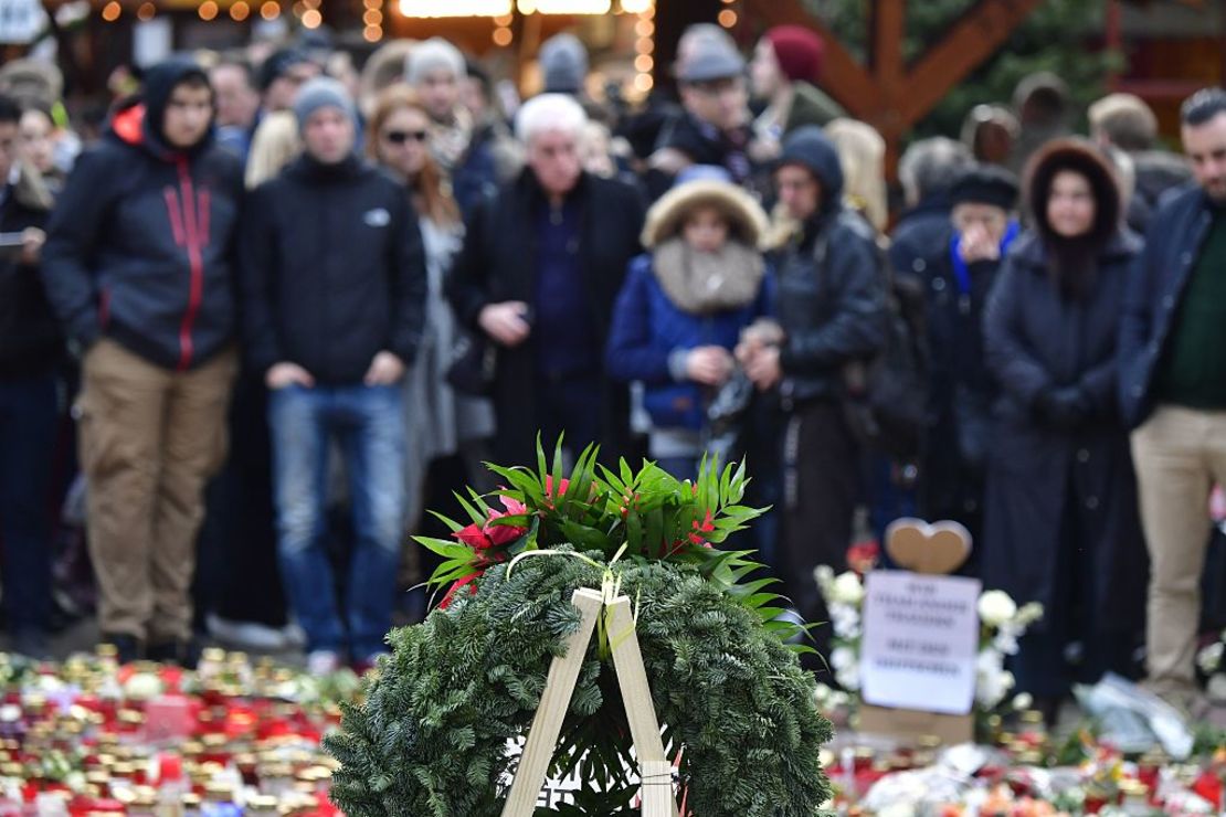 Un grupo de personas se reúne frente a un homenaje a las víctimas del ataque a Berlín.