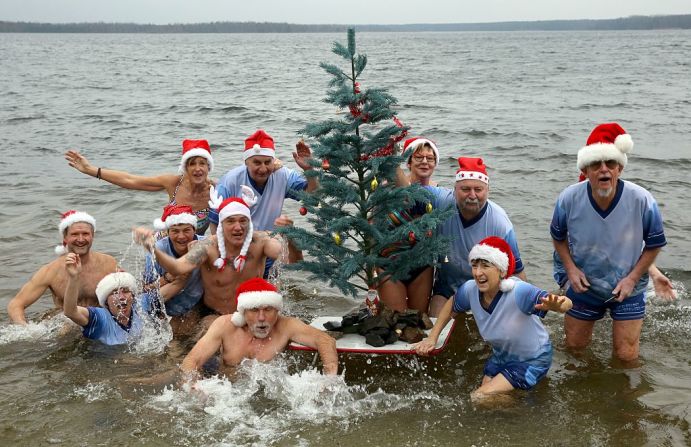 Miembros de 'Los témpanos de hielo de Senftenberger' posan para una foto durante el tradicional baño de Navidad cerca de Senftenberg, en el este de Alemania.