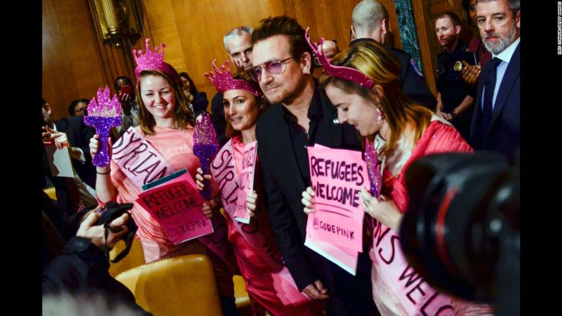 El vocalista de la agrupación irlandesa U2 posa con manifestantes ante un subcomité del Senado en Washington el 12 de abril. El cantante pidió a las autoridades darle más ayuda a los refugiados diciendo que esto ayudaría en la lucha contra la violencia extremista.