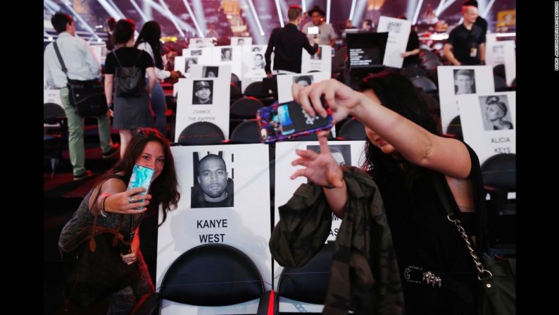 Varias personas se toman selfies donde las celebridades se sentarían durante los MTV Video Music Awards en agosto.