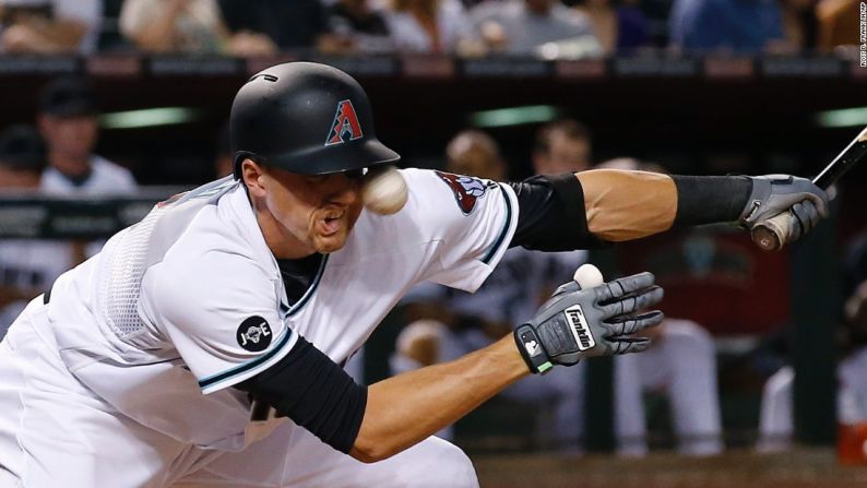 El paracortos de Arizona Nick Ahmen recibe un pelotazo en la cara durante un juego de las Grandes Ligas en Phoenix el viernes 22 de abril.