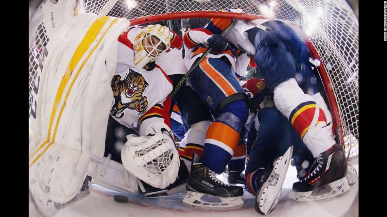 Abril 20: Varios jugadores se lanzan sobre la línea del arco que cuida el jugador de Florida Roberto Luongo, durante un partido de la NHL en Nueva York.